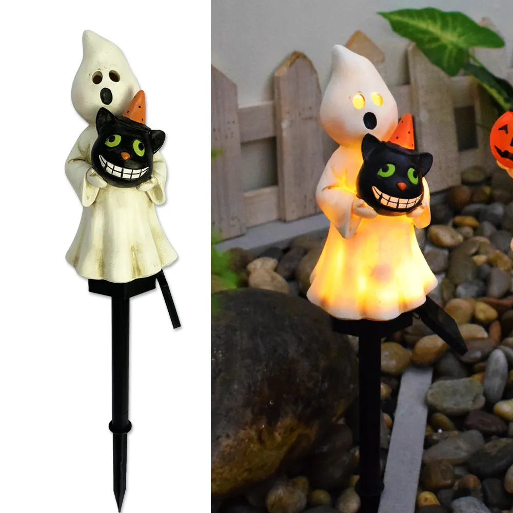 Solar Halloween pumpkin lantern with wizard pumpkin style on a garden path, wrought iron frame