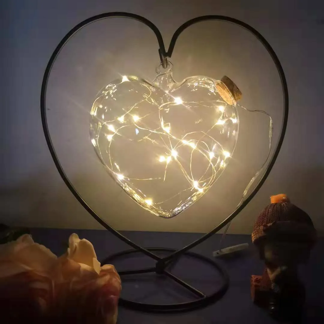 Round glass LED wishing bottle 12 cm with cork, 20 warm white lights, and folded star paper strips on a table