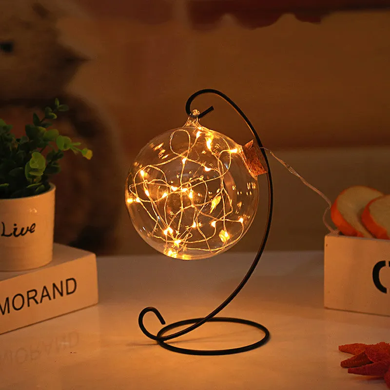 Round glass LED wishing bottle 12 cm with cork, 20 warm white lights, and folded star paper strips on a table
