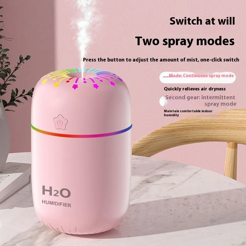 Small white USB desktop humidifier with water tank on a wooden desk.
