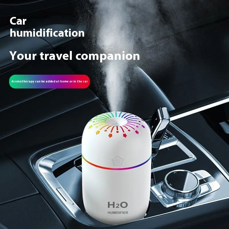 Small white USB desktop humidifier with water tank on a wooden desk.