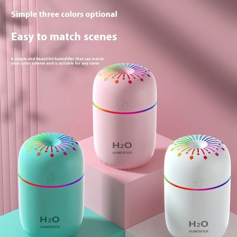 Small white USB desktop humidifier with water tank on a wooden desk.