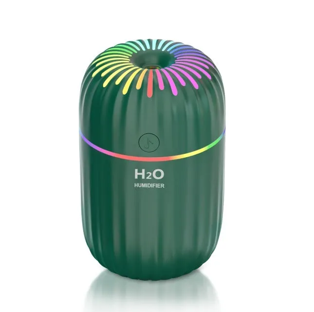 Small white USB desktop humidifier with water tank on a wooden desk.