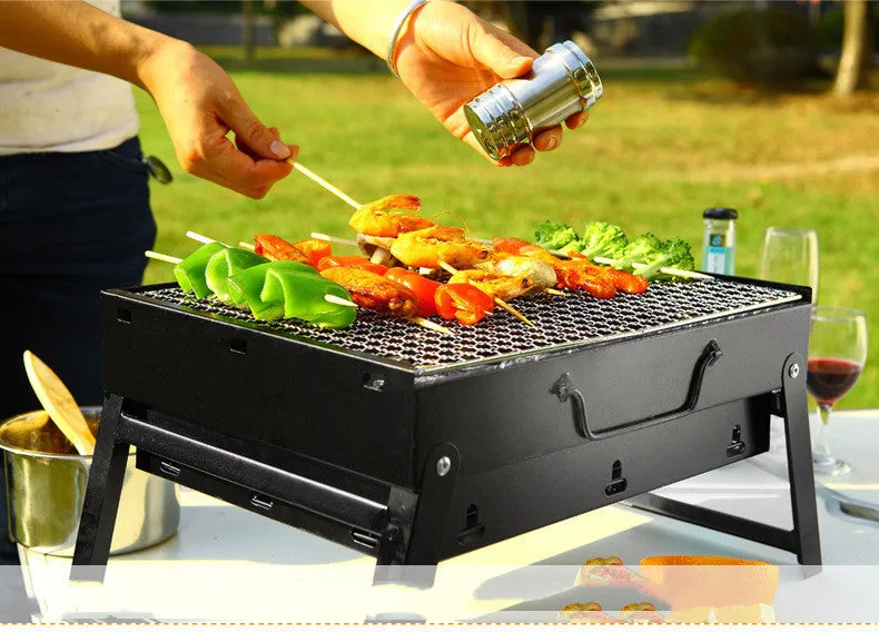 Folding portable charcoal barbecue grill on outdoor table showing 35x27x20cm cooking area