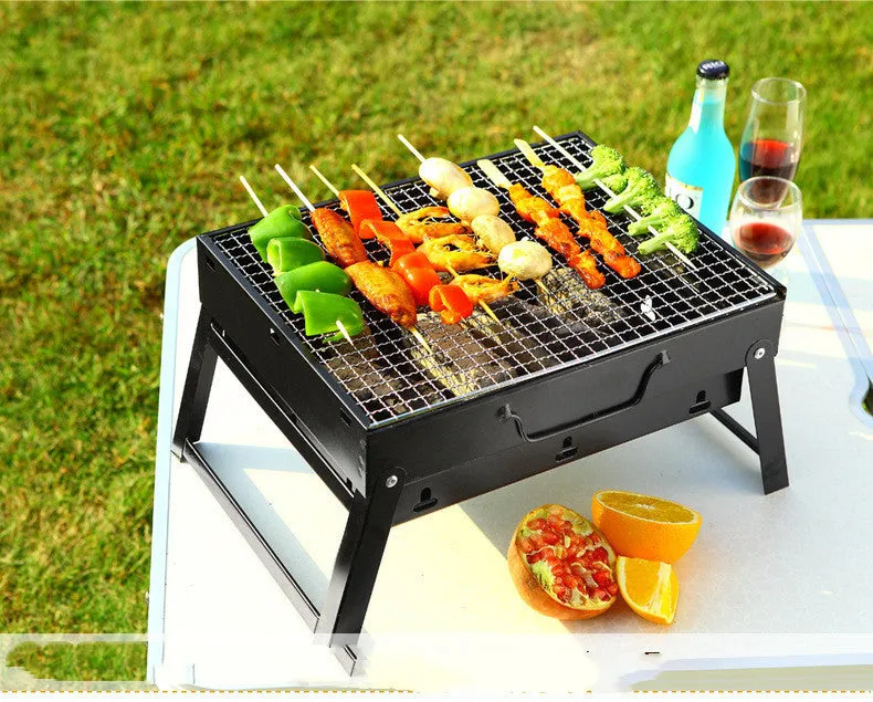 Folding portable charcoal barbecue grill on outdoor table showing 35x27x20cm cooking area