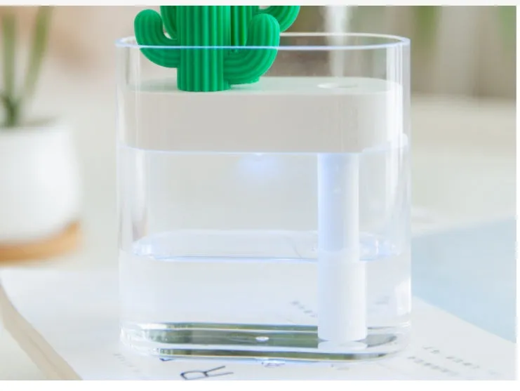 Transparent green cactus USB portable humidifier on desk showing water level inside plastic body