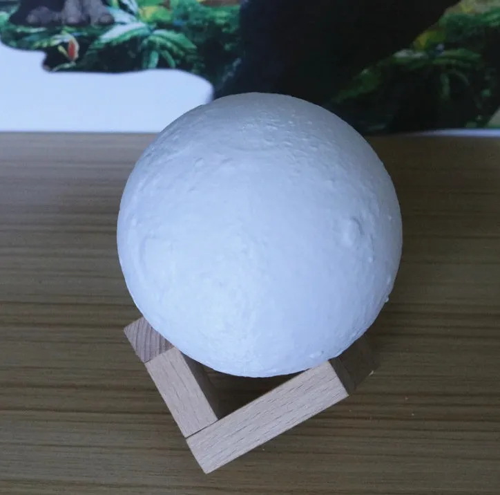 Luna Tranquil Moon Lamp with realistic moon texture and touch colour control on a bedside table
