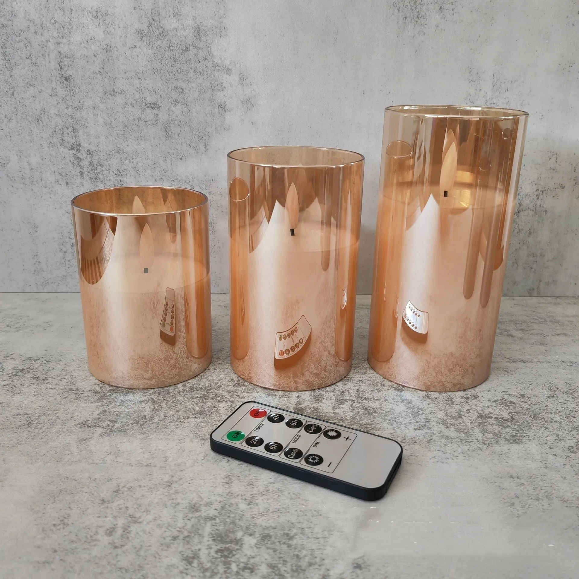 Set of three LED electronic candle lights in gold, gray, and white electroplated glass, sizes 7.5x10cm, 7.5x12.5cm, 7.5x15cm, with a remote control and USB cable.