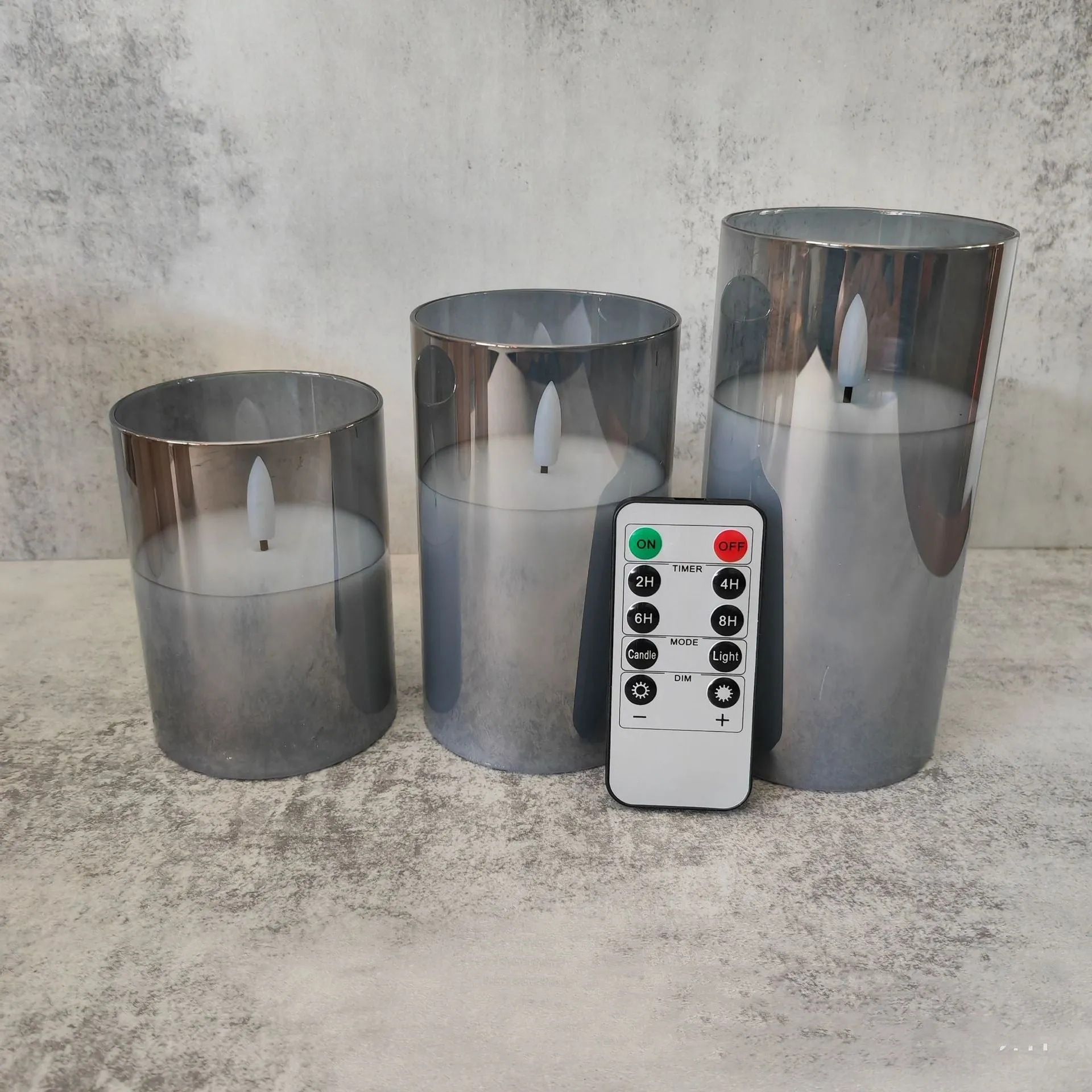 Set of three LED electronic candle lights in gold, gray, and white electroplated glass, sizes 7.5x10cm, 7.5x12.5cm, 7.5x15cm, with a remote control and USB cable.