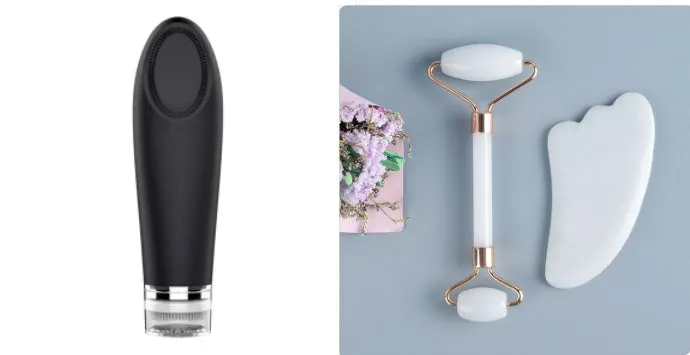 White jade facial roller with double heads and a matching gua sha scraping board on a plain surface.