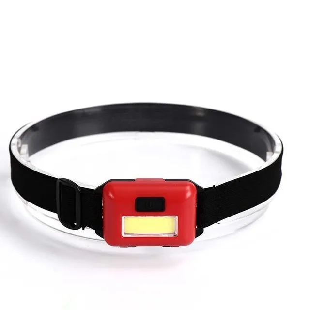 Compact outdoor mini LED headlight with headstrap in black, blue, or red colour.