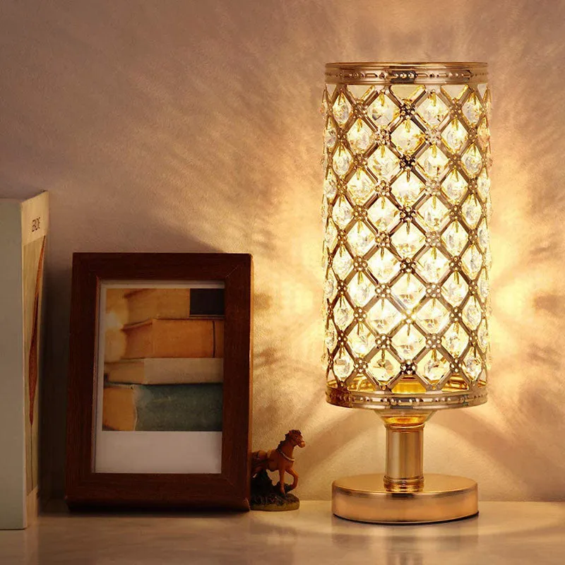 Modern crystal table lamp with hollow-carved design, metal base, gold finish, push button switch, on bedside table