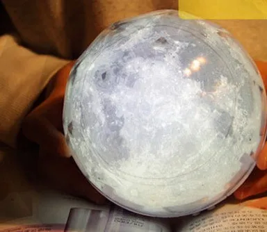 Galaxy projector lamp with diamond-shaped shell showing earth pattern on a table