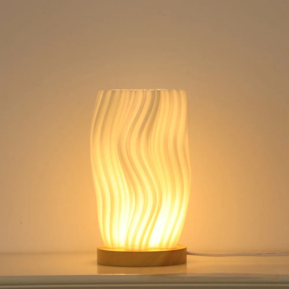 3D printed cylindrical vase night lamp in wood colour finish on a modern bedside table