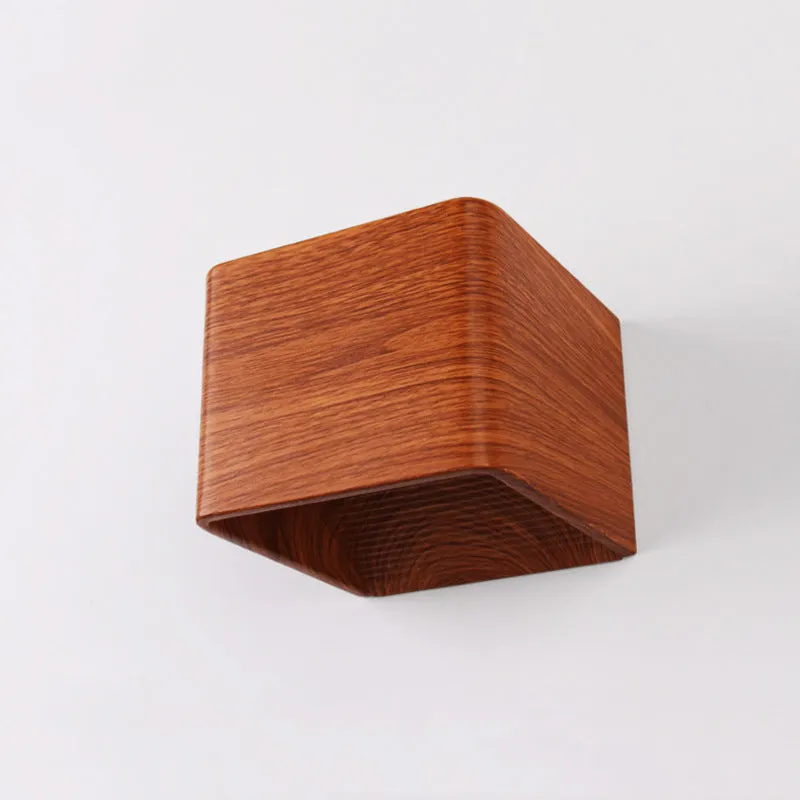 Square LED indoor wall lamp in black die-cast aluminium with warm white light on a wall