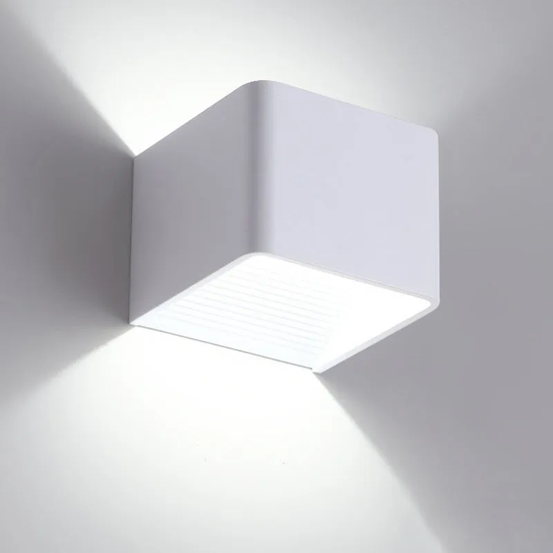 Square LED indoor wall lamp in black die-cast aluminium with warm white light on a wall