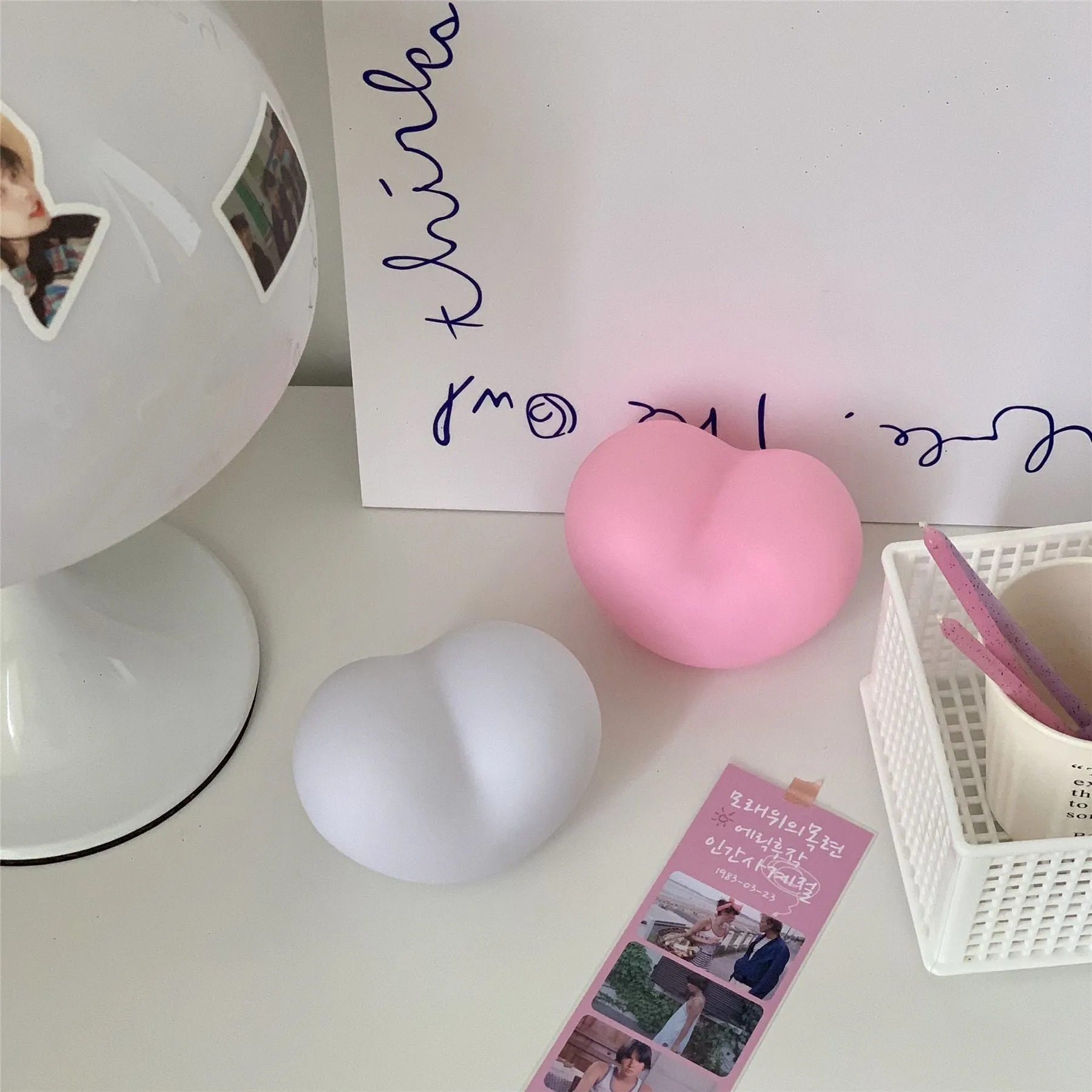 White and pink vinyl atmosphere lamp in trumpet and tuba shapes on a bedside table.