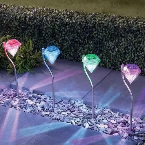 White solar-powered garden spotlight with adjustable lighting angle on a fence post.