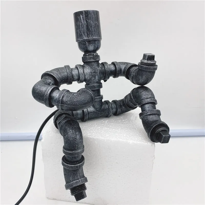 Industrial retro style water pipe robot table lamp made of iron in a vintage colour.