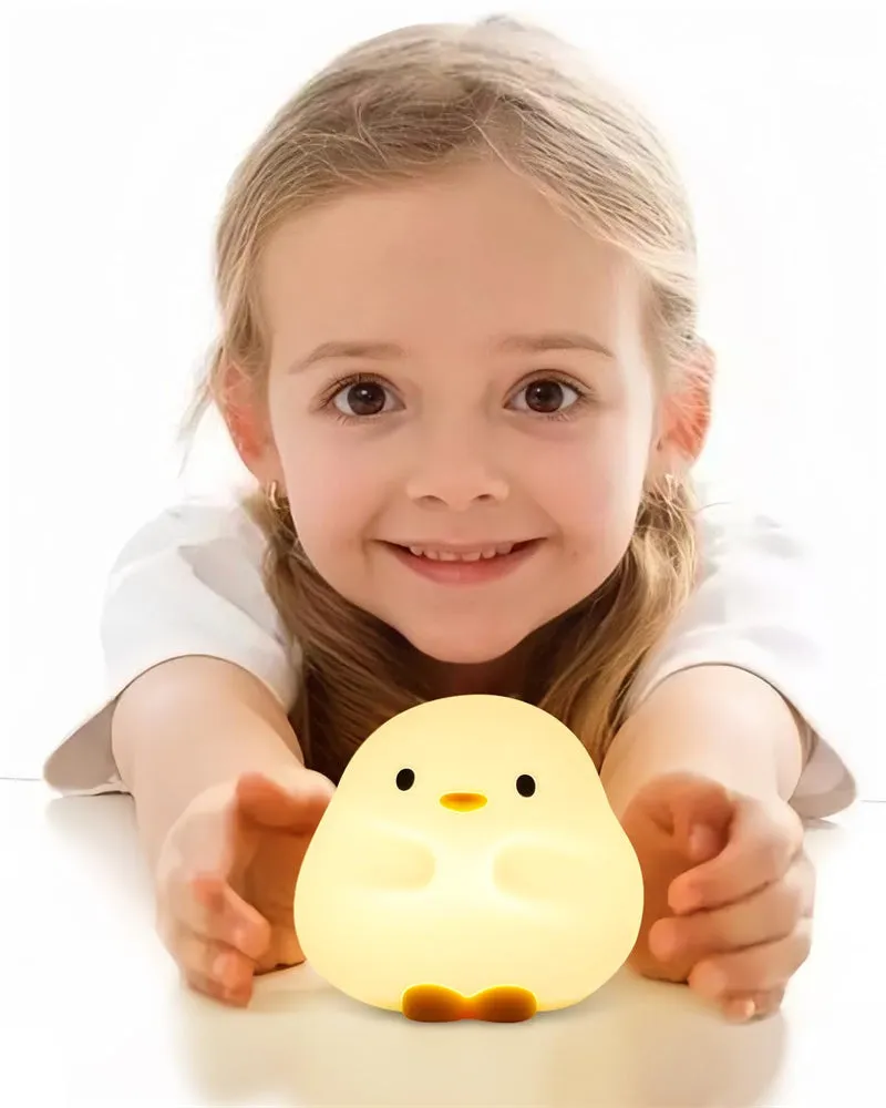 Cute duck-shaped silicone LED night lamp with touch sensor and warm glow on a bedside table