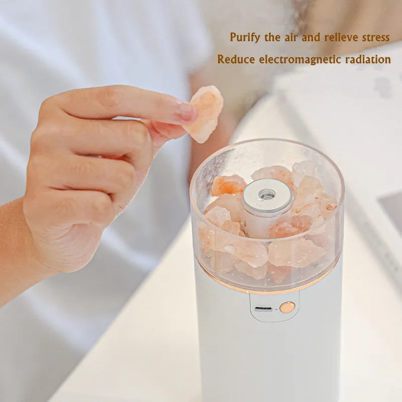 White desktop ultrasonic humidifier with crystal salt stone and LED lamp showing side view on table