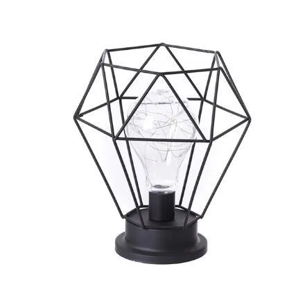 Hollow wrought iron wine bottle shaped table lamp with warm white LED light on a wooden desk