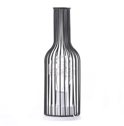 Hollow wrought iron wine bottle shaped table lamp with warm white LED light on a wooden desk