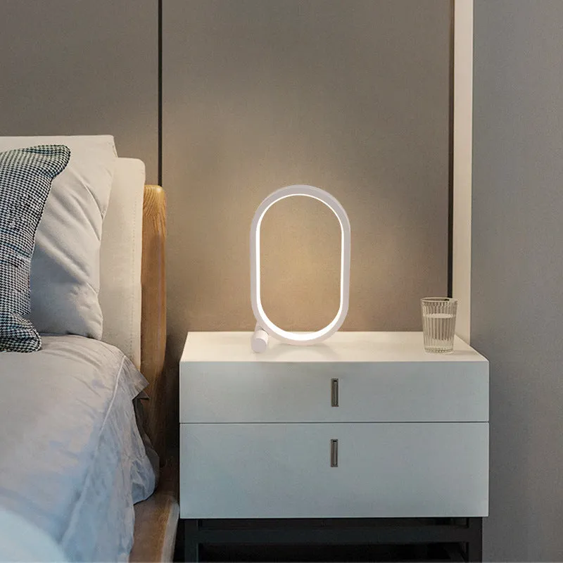 USB plug-in oval acrylic touch dimmable night light with metal base on a desk, black colour