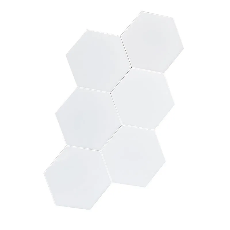 Colourful hexagonal LED wall lamp with remote control displaying rainbow effect on a bedroom wall