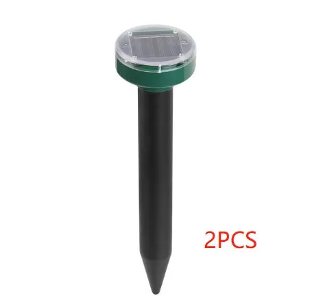 Solar ultrasonic mouse repeller with black solar panel and battery unit on grassy ground