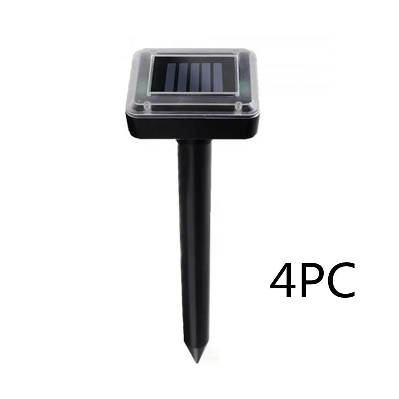 Solar ultrasonic mouse repeller with black solar panel and battery unit on grassy ground