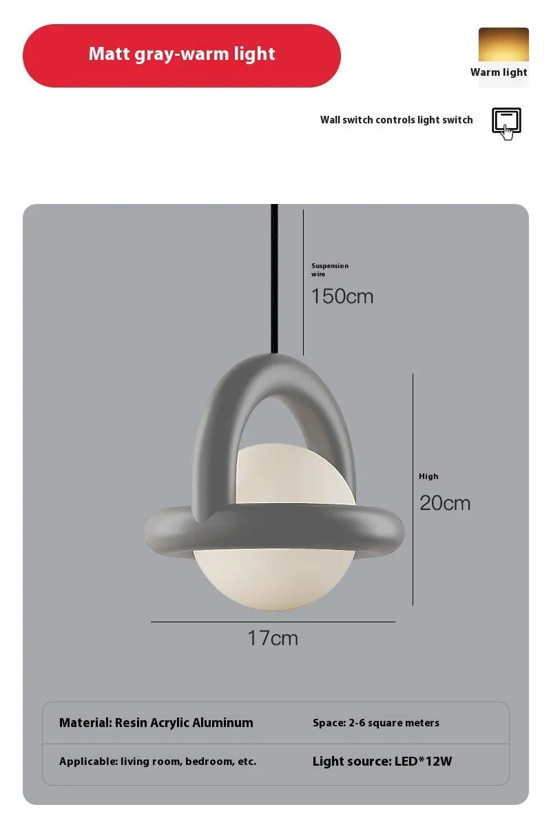 Matte black hanging line lamp with a long black cord suspended above a bedside table.