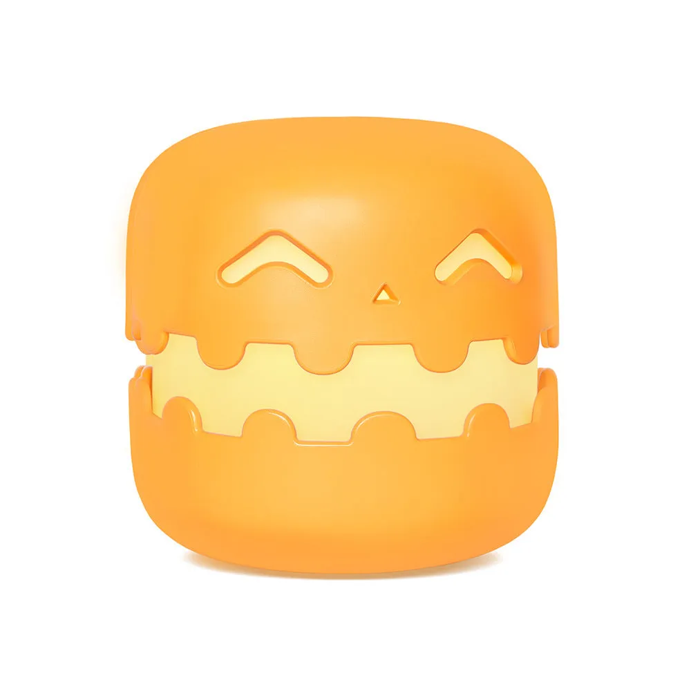 Pumpkin-shaped silicone LED night light in orange and green colour, 102mm by 94mm, with soft glow on a bedside table