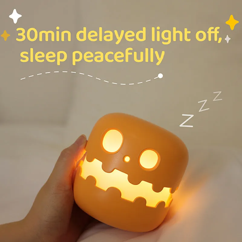 Pumpkin-shaped silicone LED night light in orange and green colour, 102mm by 94mm, with soft glow on a bedside table