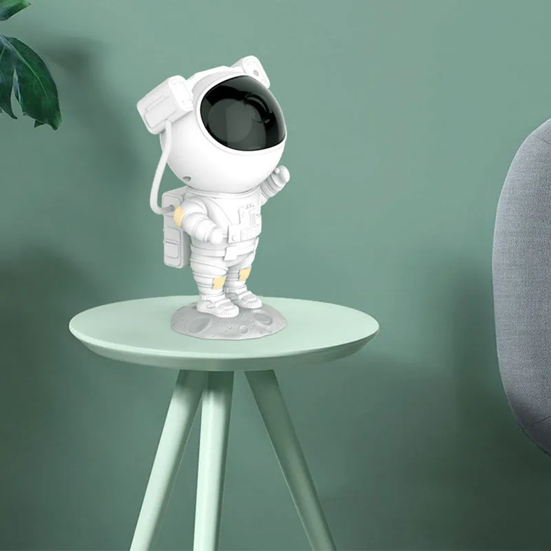 Creative astronaut galaxy starry sky projector nightlight on a table with nebula and star effects displayed against a dark background