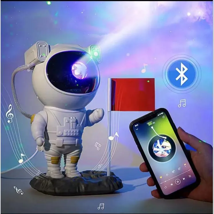 Creative astronaut galaxy starry sky projector nightlight on a table with nebula and star effects displayed against a dark background