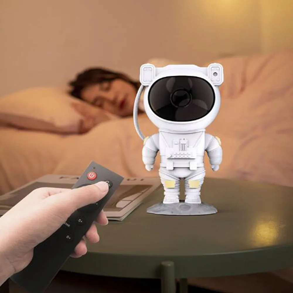 Creative astronaut galaxy starry sky projector nightlight on a table with nebula and star effects displayed against a dark background
