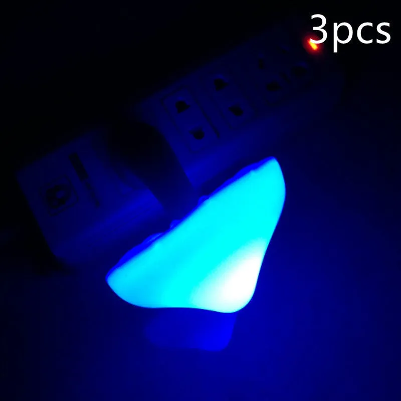 Mushroom-shaped LED night light with light sensor, warm yellow glow, plugging into a wall socket