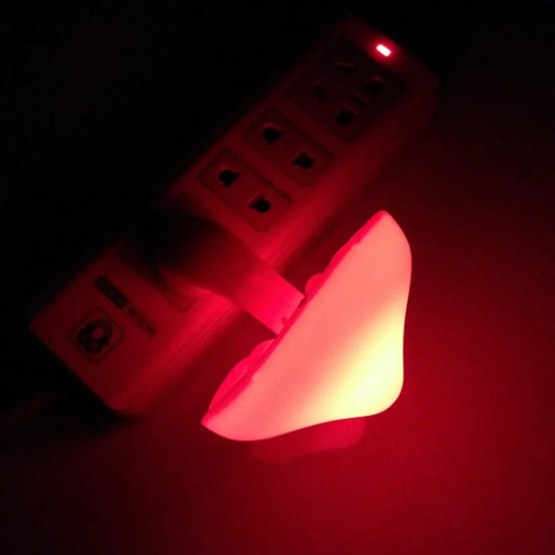 Mushroom-shaped LED night light with light sensor, warm yellow glow, plugging into a wall socket