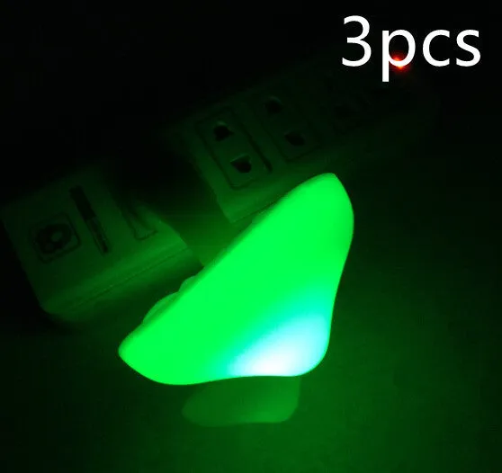 Mushroom-shaped LED night light with light sensor, warm yellow glow, plugging into a wall socket