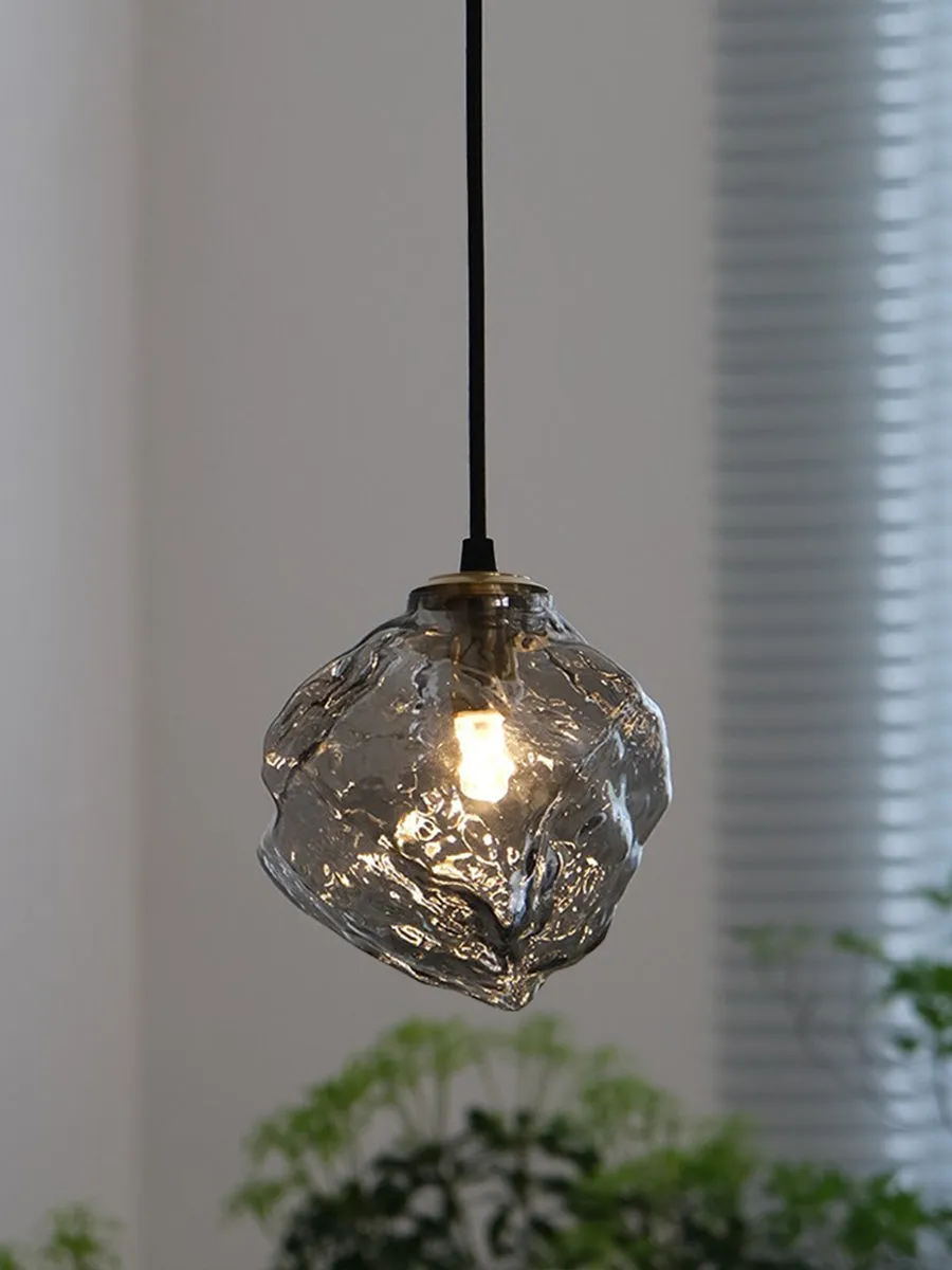 Minimalist ice cube glass chandelier with warm 4000K light, smoky grey shade and black hanging wire over a dining table