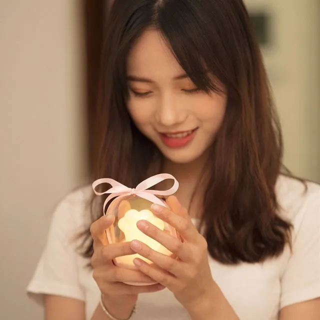 Grey and pink cat paw shaped USB rechargeable night light with rotating dynamic lighting