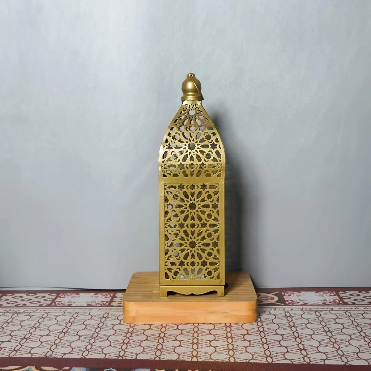 Gold L decorative iron barn lantern with hollow four-corner design on a tabletop