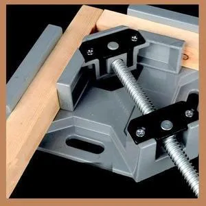 Black aluminium alloy 90 degree right angle clip with 70mm opening on a wooden workbench.