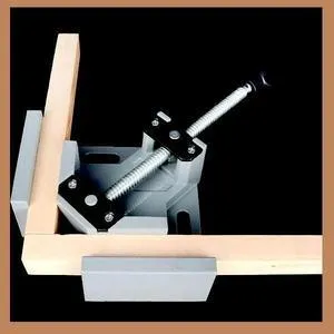 Black aluminium alloy 90 degree right angle clip with 70mm opening on a wooden workbench.