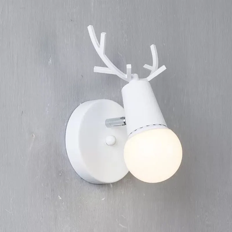 Wrought iron wall lamp with wooden antler-style shade on a white wall