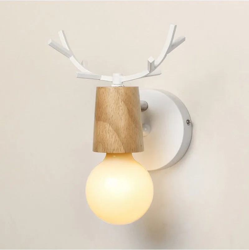 Wrought iron wall lamp with wooden antler-style shade on a white wall