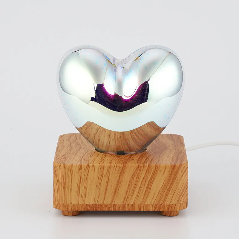 3D love glass small night lamp with silver electroplated finish and solid wood base on a bedside table