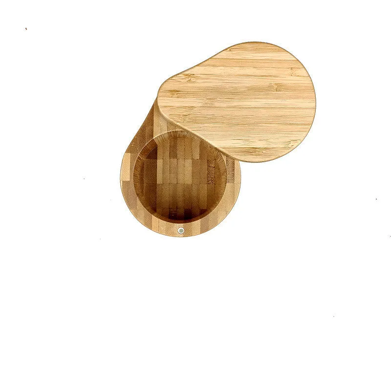 Bamboo seasoning storage box with a small bamboo spoon on a kitchen counter.