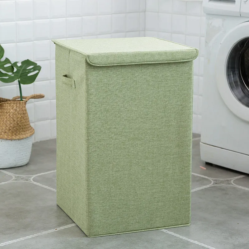 Washable fabric laundry sorting box in beige, shown next to a small pile of towels.